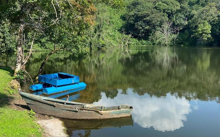 Crystal-clear crater lake surrounded by forest at Lake Nkuruba Nature Reserve